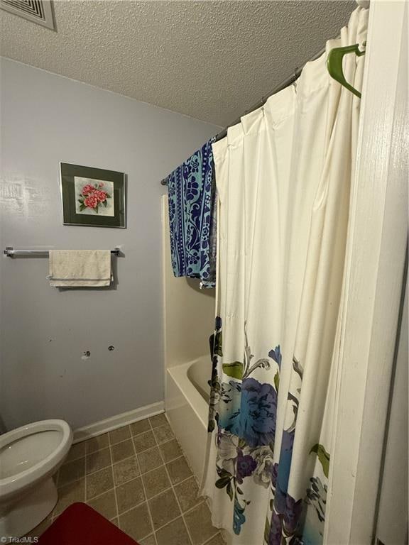 bathroom featuring shower / bathtub combination with curtain, a textured ceiling, and toilet