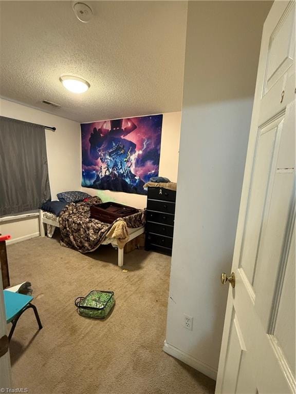 bedroom with light carpet and a textured ceiling