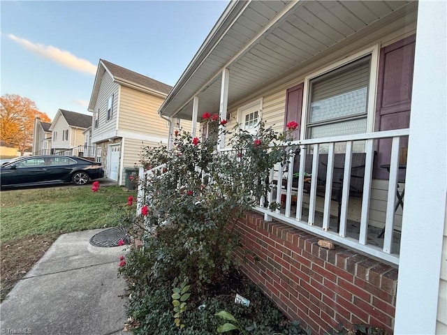 view of side of property featuring a lawn and covered porch