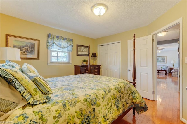 bedroom with a textured ceiling, hardwood / wood-style floors, and a closet