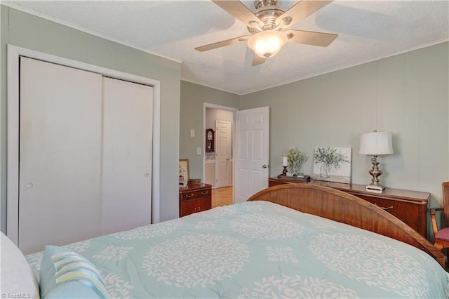 bedroom featuring ceiling fan, crown molding, and a closet