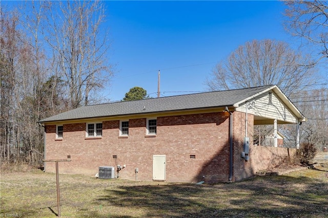 view of home's exterior featuring crawl space, brick siding, a yard, and central AC