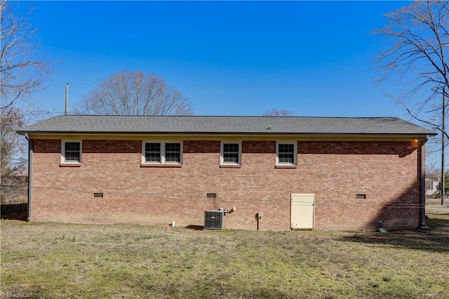 view of home's exterior featuring crawl space, central AC unit, a lawn, and brick siding