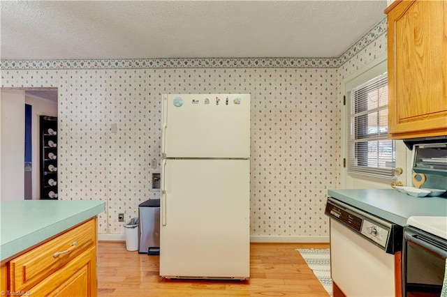 kitchen featuring white appliances, wallpapered walls, baseboards, light wood-style flooring, and light countertops