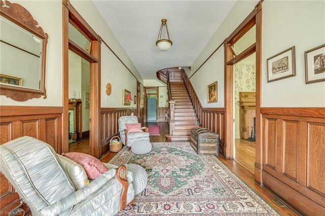 living area featuring hardwood / wood-style flooring and wooden walls