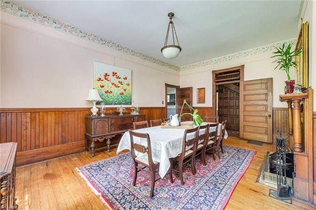 dining area featuring hardwood / wood-style floors and wooden walls