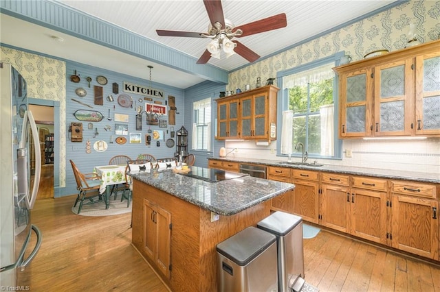 kitchen featuring a healthy amount of sunlight, ceiling fan, a kitchen island, and light hardwood / wood-style flooring