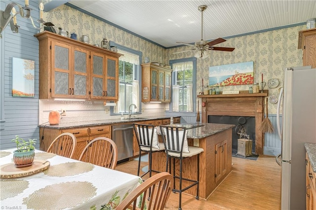 kitchen with stainless steel dishwasher, sink, ceiling fan, white refrigerator, and light wood-type flooring