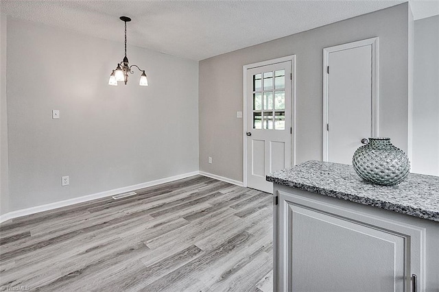 5948 Muddy Creek Rd, Archdale, NC 27263 - entryway featuring a chandelier, light wood-style flooring, a textured ceiling, and baseboards