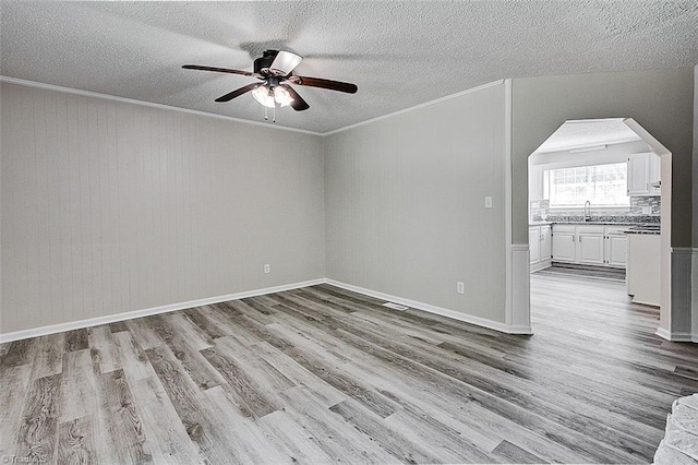 5948 Muddy Creek Rd, Archdale, NC 27263 - unfurnished room featuring ceiling fan, wood finished floors, ornamental molding, a textured ceiling, and arched walkways