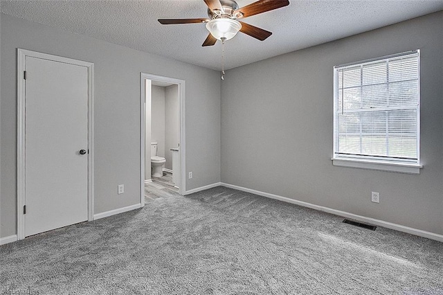 5948 Muddy Creek Rd, Archdale, NC 27263 - unfurnished bedroom featuring carpet flooring, a textured ceiling, baseboards, connected bathroom, and ceiling fan