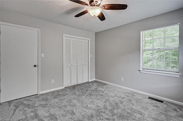 5948 Muddy Creek Rd, Archdale, NC 27263 - unfurnished bedroom featuring carpet floors, a textured ceiling, a closet, a ceiling fan, and baseboards