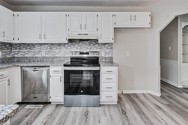 5948 Muddy Creek Rd, Archdale, NC 27263 - kitchen with appliances with stainless steel finishes, under cabinet range hood, light wood finished floors, white cabinetry, and tasteful backsplash
