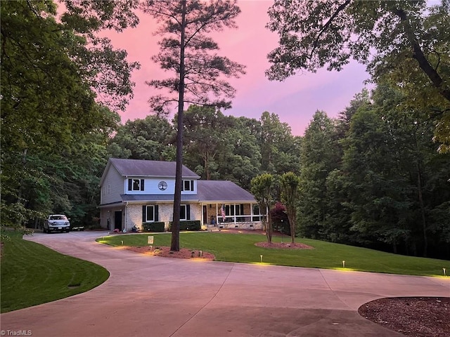 view of front of property with a porch and a lawn