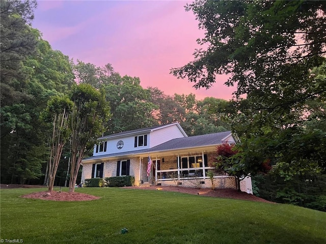 view of front of home featuring a lawn and covered porch