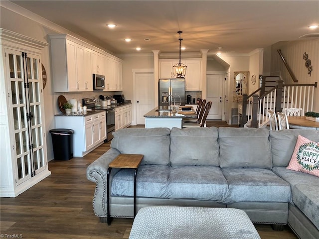 living room with an inviting chandelier, ornamental molding, dark hardwood / wood-style floors, and sink