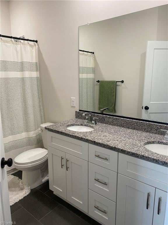 bathroom featuring a shower with curtain, vanity, toilet, and tile patterned floors