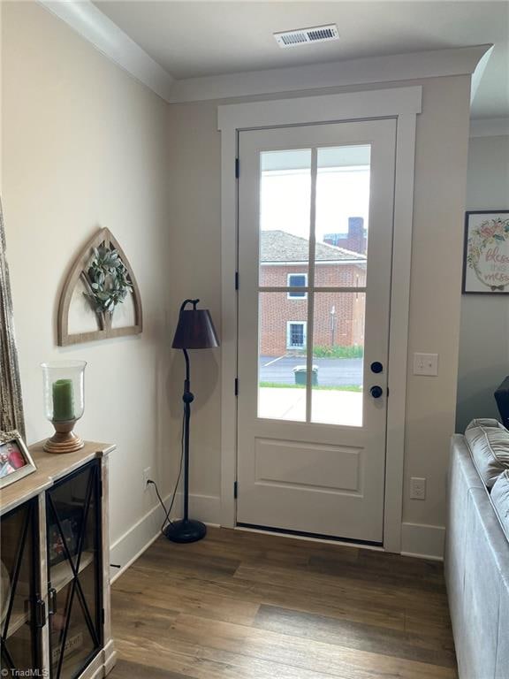 entryway featuring crown molding and dark wood-type flooring