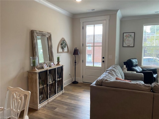 interior space with hardwood / wood-style flooring, crown molding, and a healthy amount of sunlight