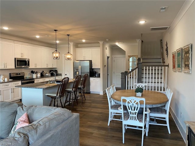 dining room with crown molding, sink, and dark wood-type flooring