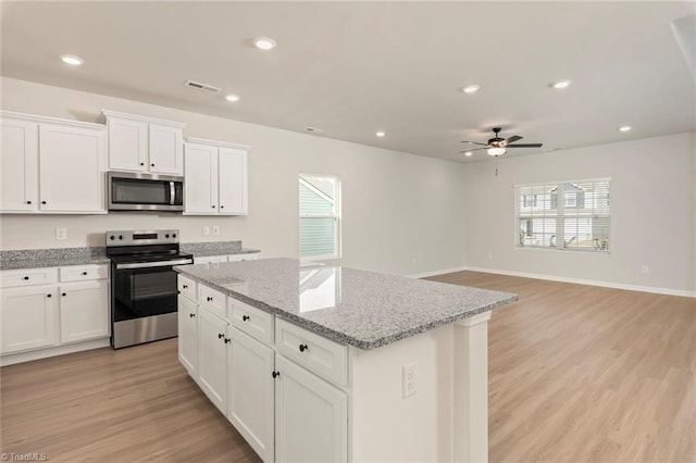 239 Dixieland Ct, King, NC 27021 - kitchen featuring stainless steel appliances, a center island, light wood finished floors, healthy amount of natural light, and recessed lighting