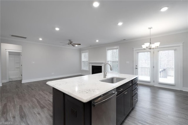 kitchen with a center island with sink, sink, crown molding, stainless steel dishwasher, and decorative light fixtures