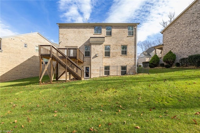 rear view of property featuring a lawn and a deck