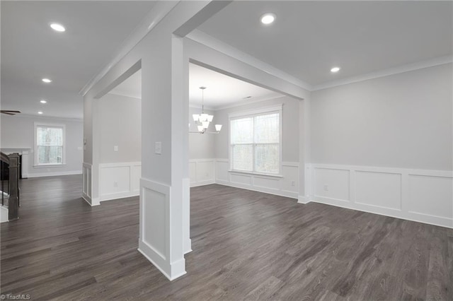 empty room with a chandelier, dark hardwood / wood-style floors, and ornamental molding