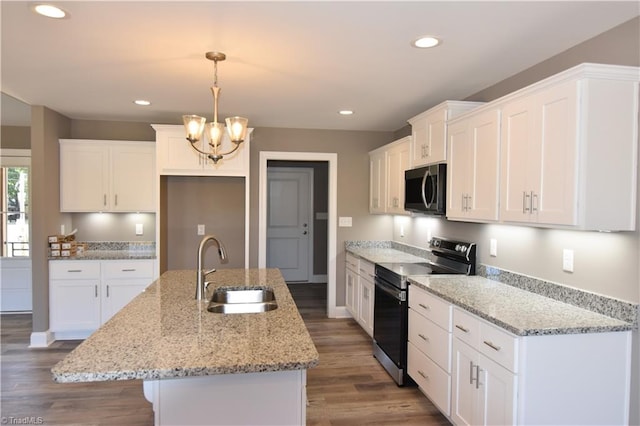 kitchen featuring an island with sink, appliances with stainless steel finishes, hardwood / wood-style floors, and white cabinetry