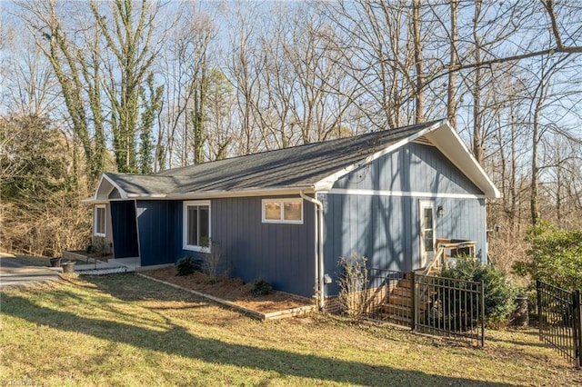 view of property exterior with a lawn and fence