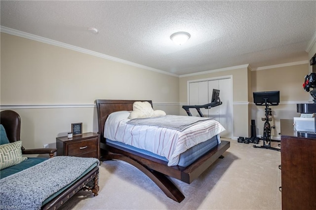 bedroom featuring a textured ceiling, ornamental molding, a closet, and light colored carpet