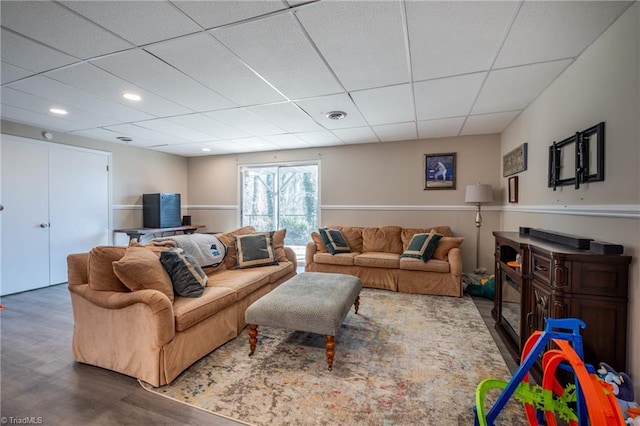 living area with a drop ceiling, wood finished floors, visible vents, and recessed lighting