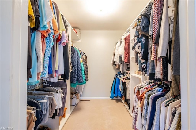 spacious closet featuring light colored carpet