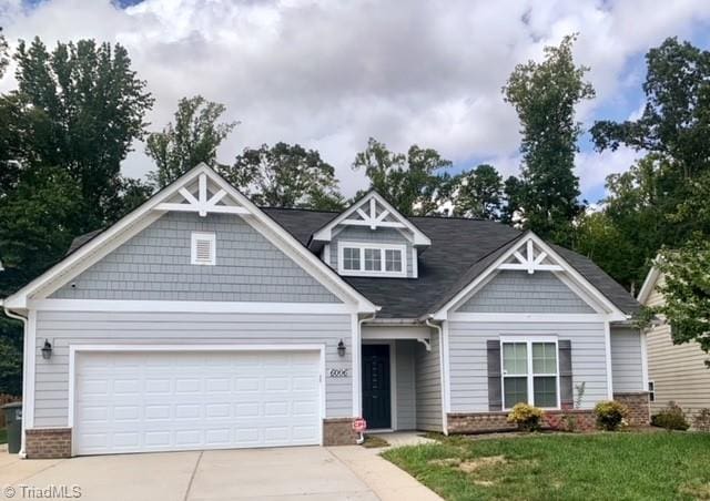 craftsman house featuring a garage and a front yard