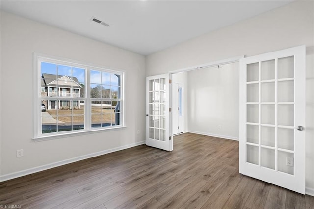 spare room featuring hardwood / wood-style floors and french doors