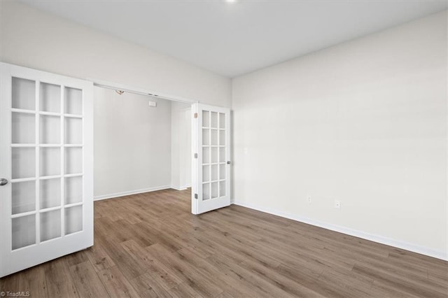 unfurnished room featuring hardwood / wood-style flooring and french doors