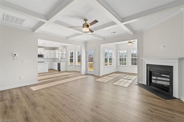 unfurnished living room featuring coffered ceiling, ceiling fan with notable chandelier, beamed ceiling, and light wood-type flooring