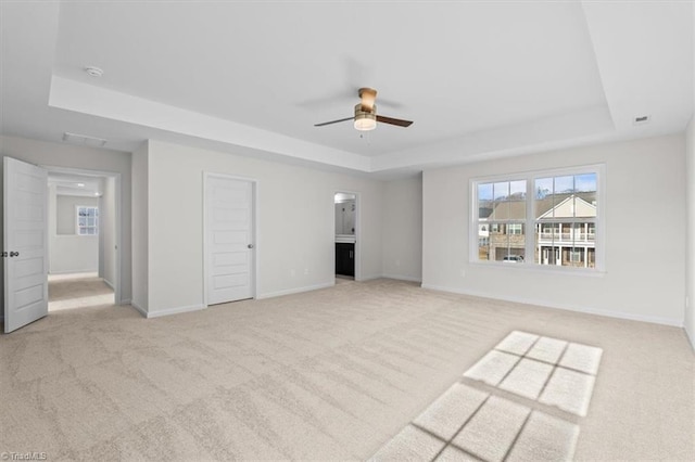 interior space featuring a tray ceiling and light carpet