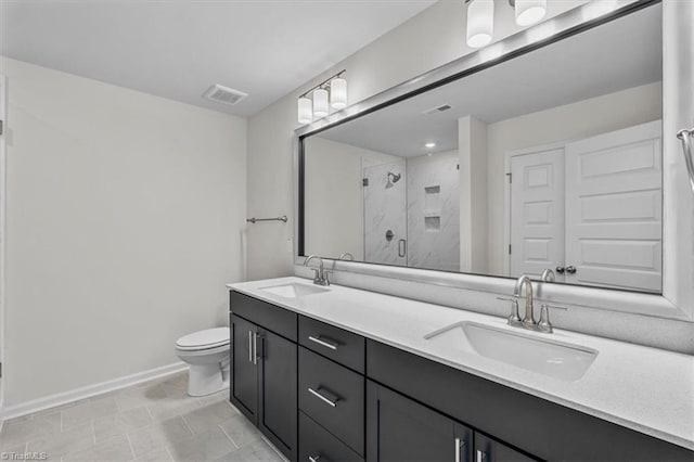 bathroom with vanity, a shower with shower door, and toilet