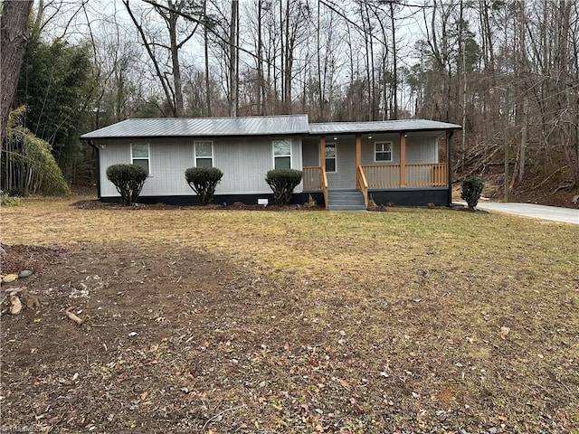 view of front of house featuring a front yard, covered porch, and metal roof