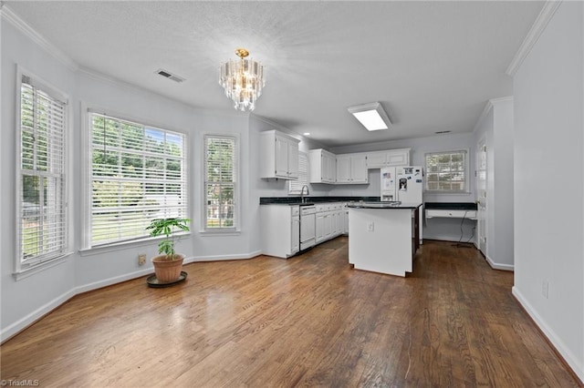 kitchen with crown molding, dark countertops, visible vents, and dark wood-type flooring