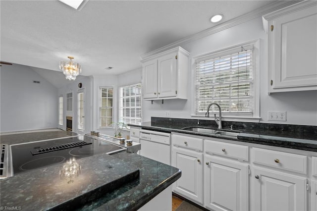 kitchen featuring dishwasher, a sink, white cabinets, dark stone countertops, and an inviting chandelier