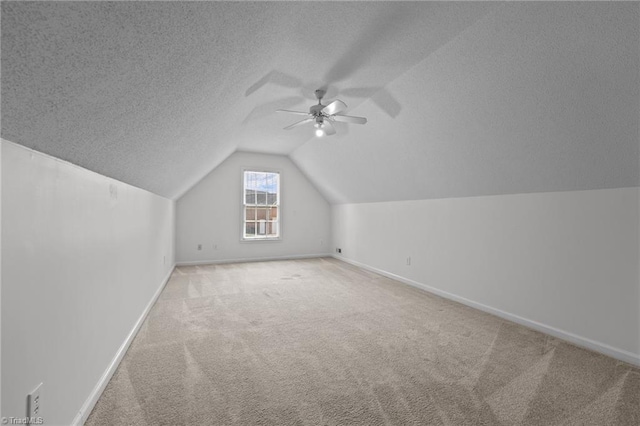 additional living space featuring baseboards, a textured ceiling, ceiling fan, and carpet floors