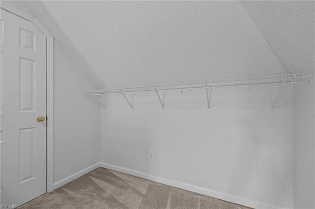 walk in closet featuring carpet and lofted ceiling