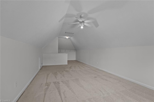 additional living space with ceiling fan, visible vents, vaulted ceiling, baseboards, and carpet