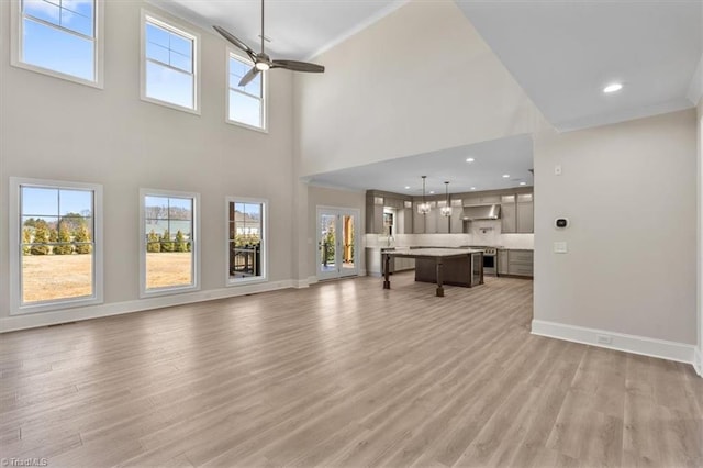 unfurnished living room featuring light wood-style flooring, recessed lighting, a ceiling fan, and baseboards