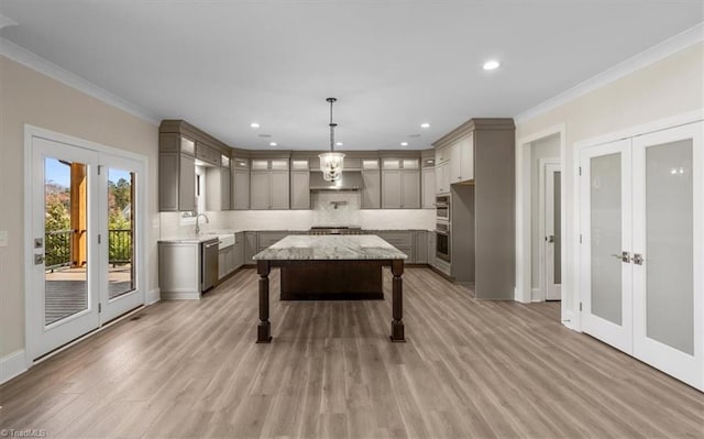 recreation room with a sink, french doors, light wood-style floors, and crown molding