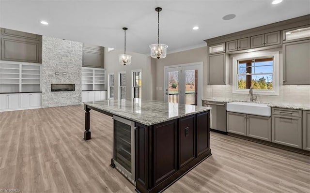 kitchen featuring beverage cooler, plenty of natural light, dishwasher, and a sink