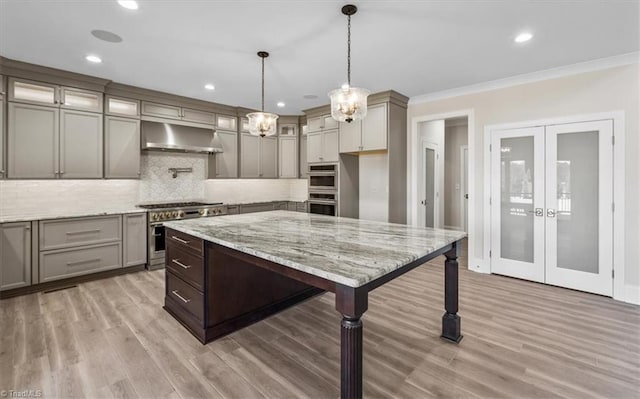 kitchen with decorative backsplash, french doors, under cabinet range hood, and stainless steel appliances