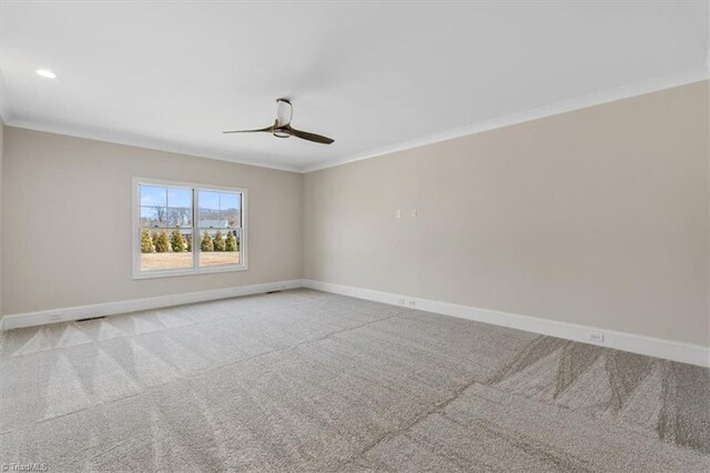 empty room featuring ceiling fan, carpet flooring, baseboards, and ornamental molding